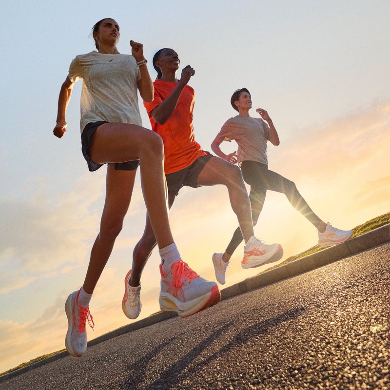 Three runners in ASICS running shoes at sunset