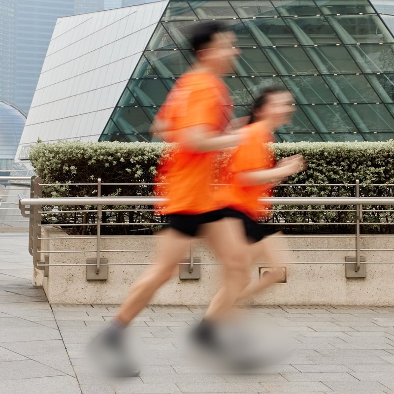 Two runners in orange Global 6K tees running at Marina Bay