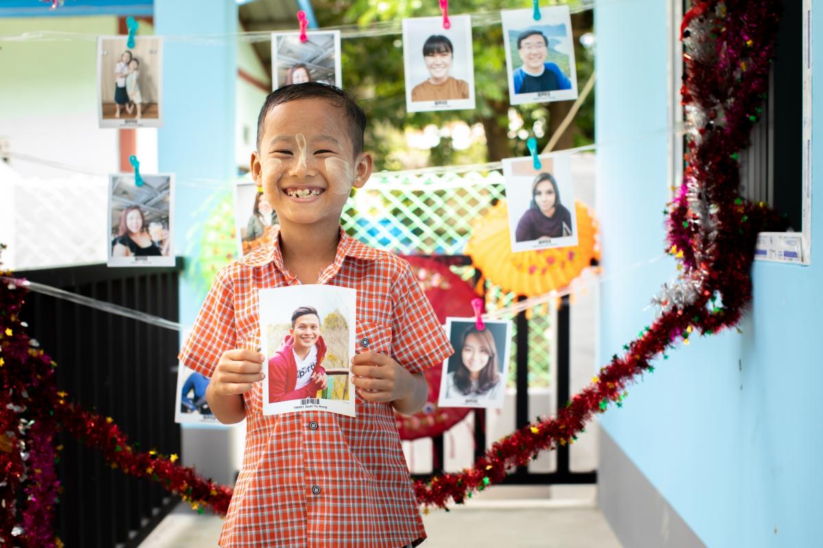 A child in Myanmar with the photo of a sponsor he has chosen 