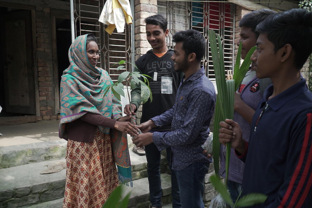 Abul and his friends from the Child Forum giving out tree seedlings to his community.