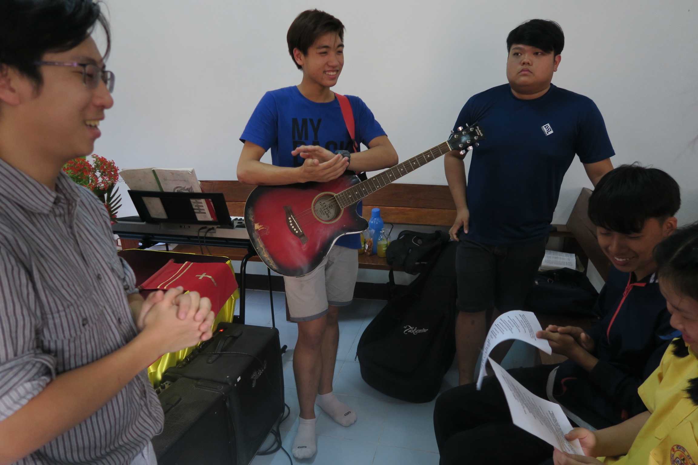 Teaching a song to a youth at a church.