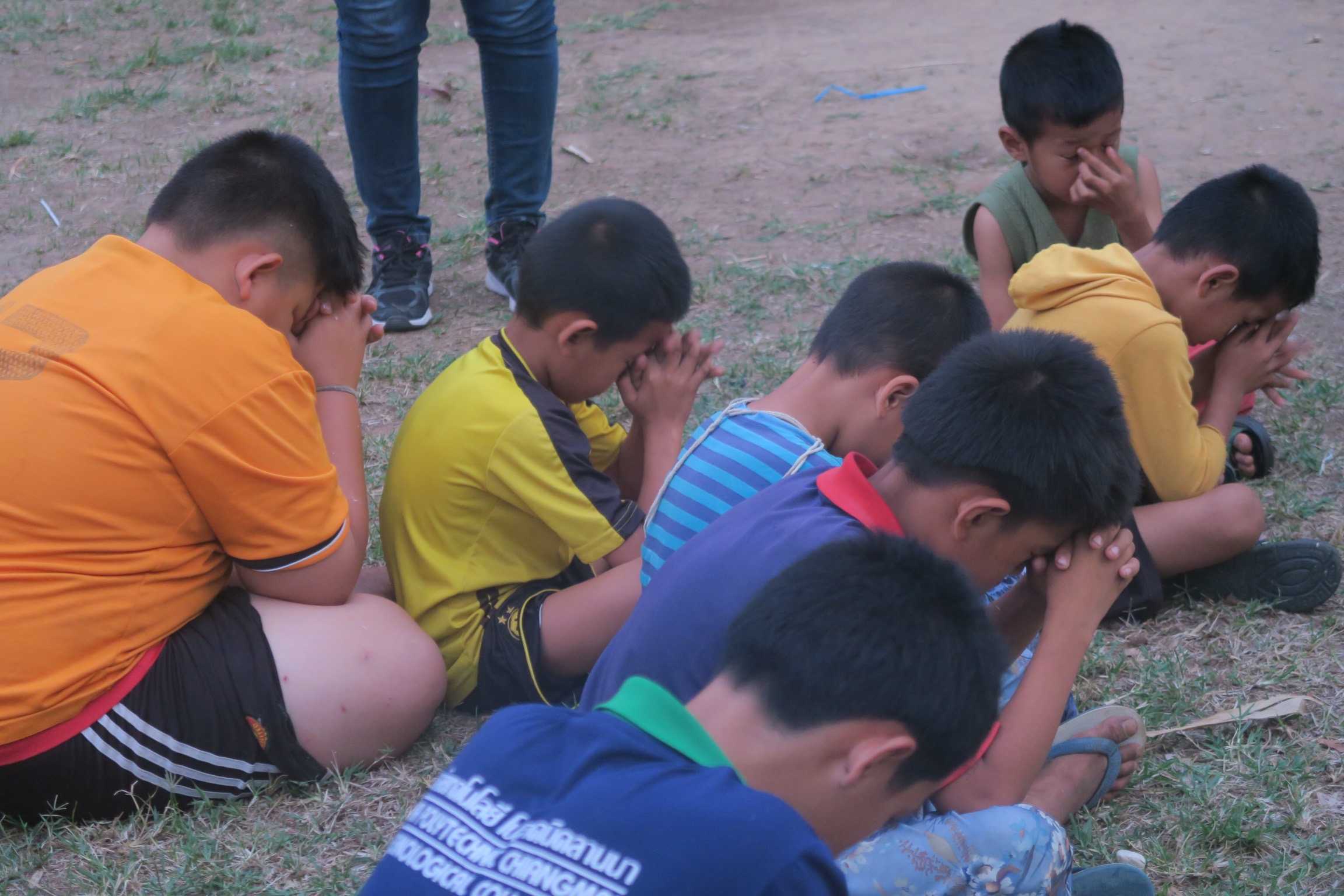 Children praying after a time of fellowship over football.