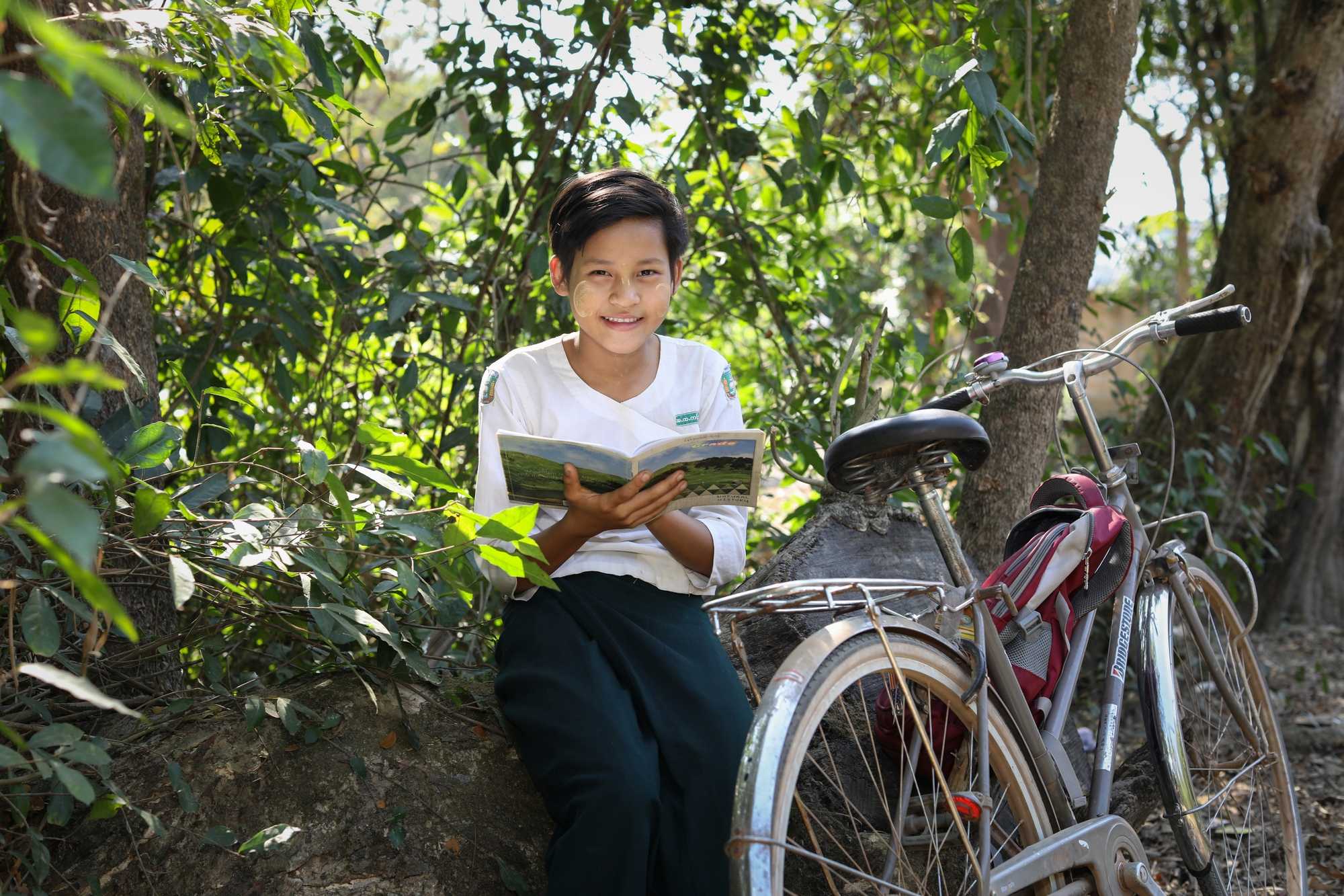 Girl smiling and posing beside her bicycle