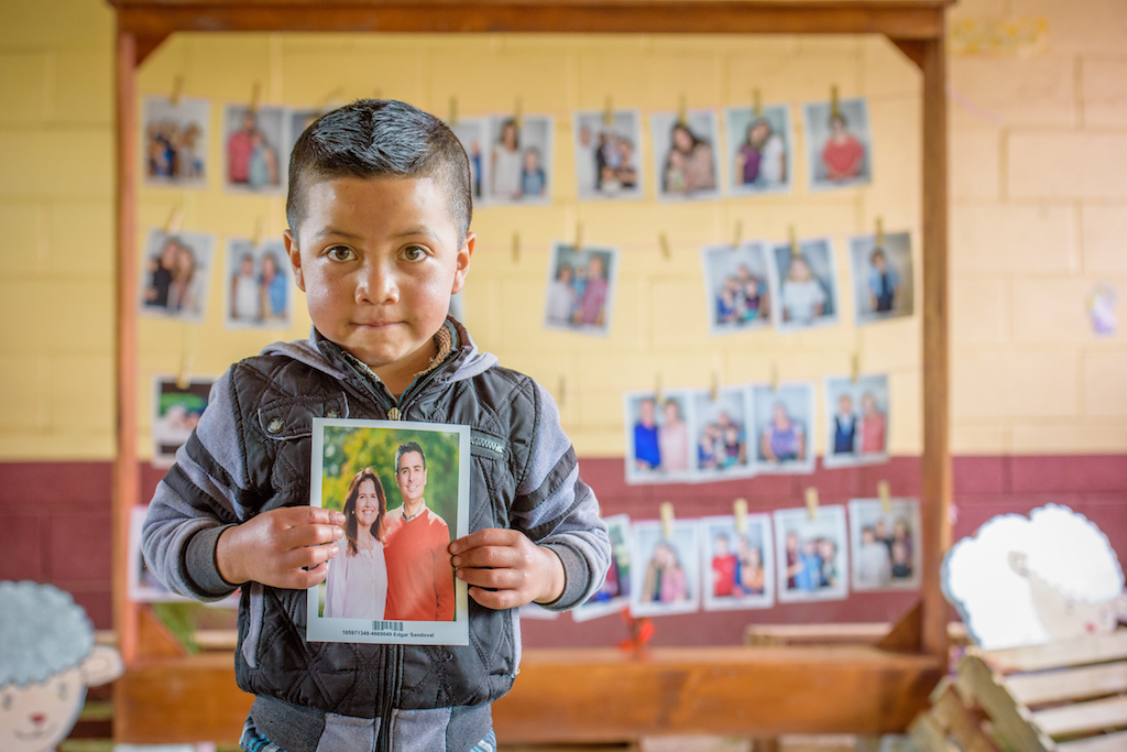 Six-year-old Wuilmer Garcia Tomas of Guatemala holds a picture of his sponsor, World Vision U.S. President Edgar Sandoval Sr., pictured with his wife, Leiza Sandoval. (©2019 World Vision/photo by Laura Reinhardt)