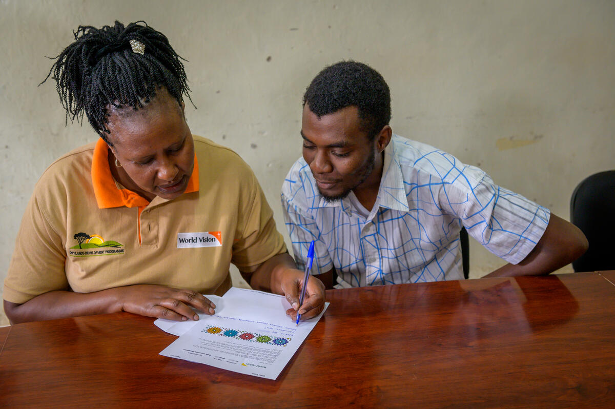 World Vision staff and volunteer working on a translating letter