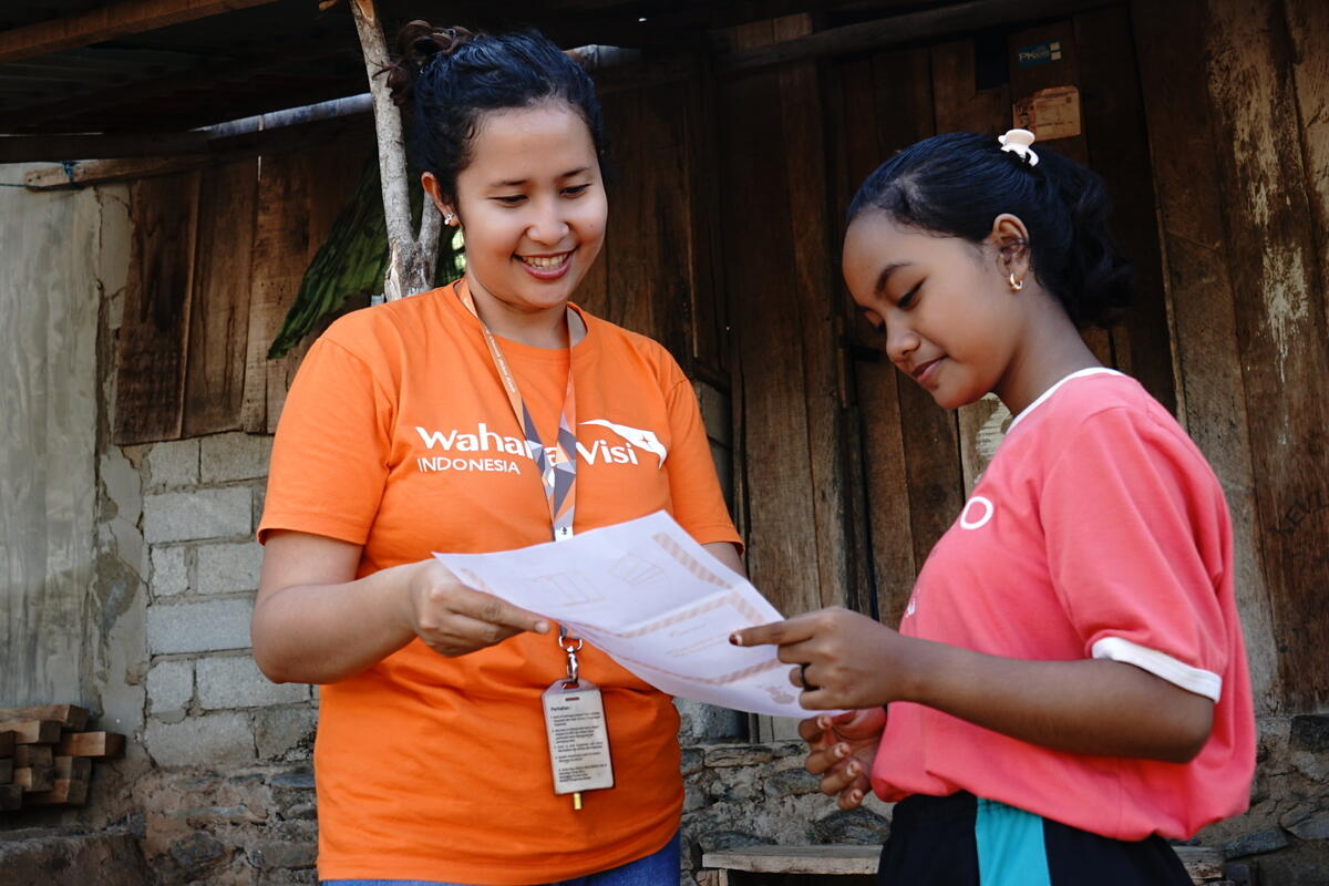 World Vision staff hand-delivering a letter to a sponsored child