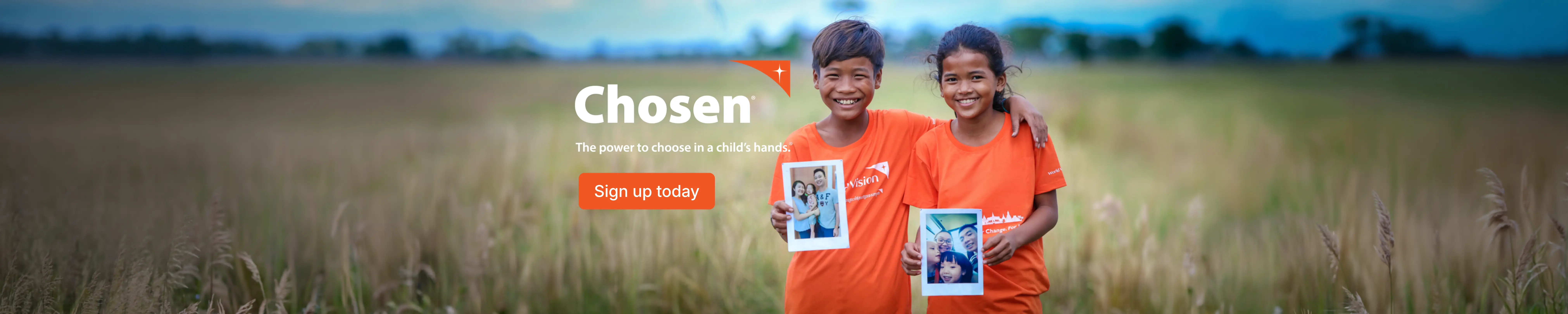 Chosen in Bohol Children holding up their sponsor's photos in a field