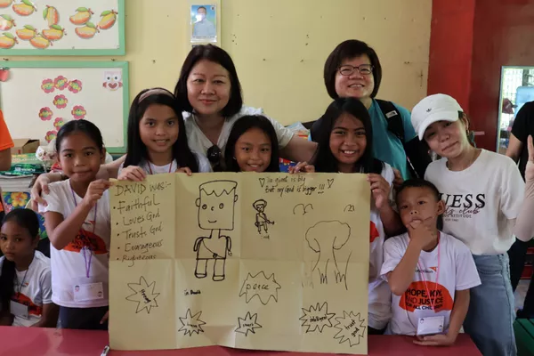Carmen (in blue shirt) with fellow trippers engaging the children in educational activities