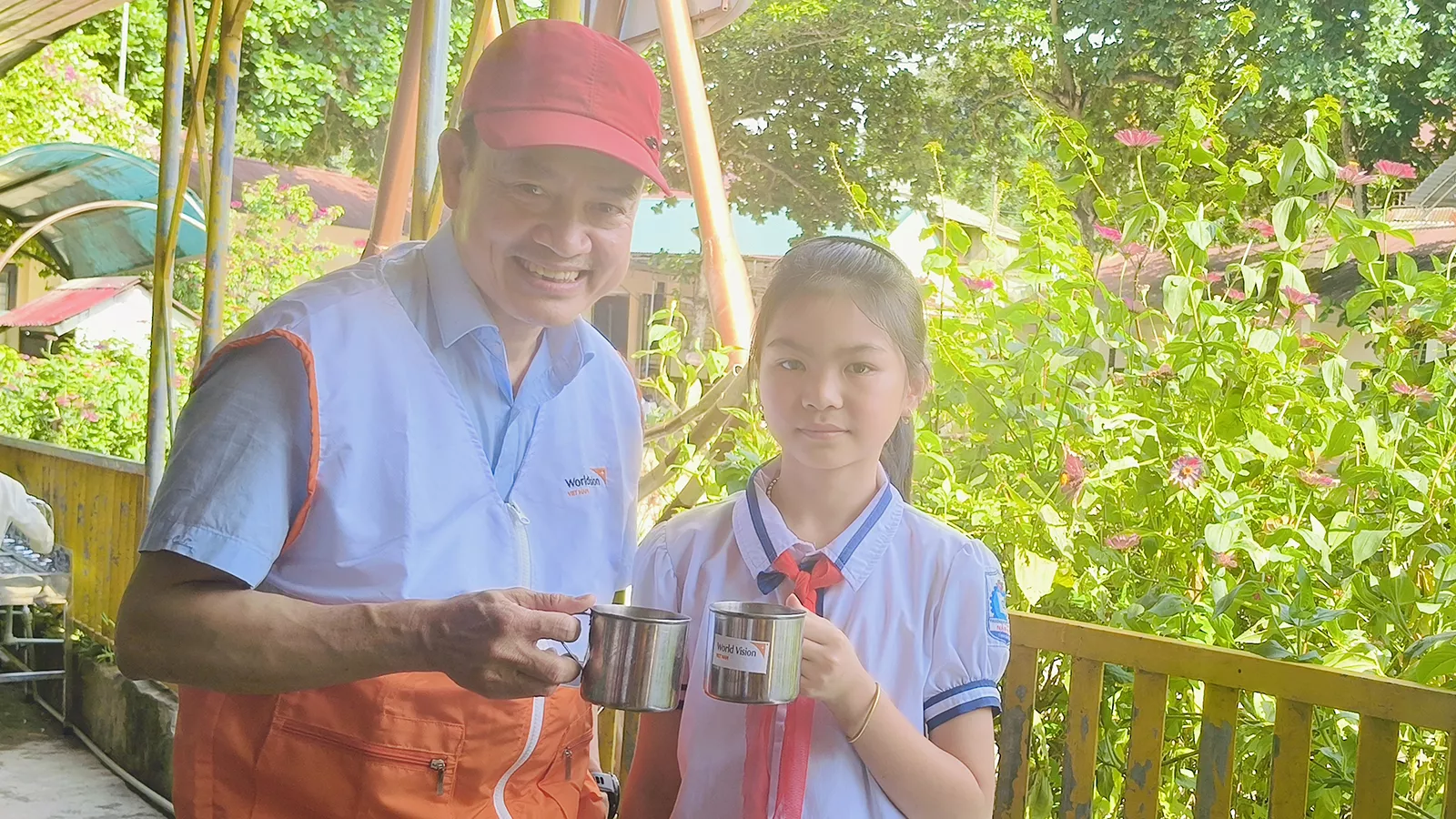 11-year-old Huyuen Ca Thanh holding a cup of clean water