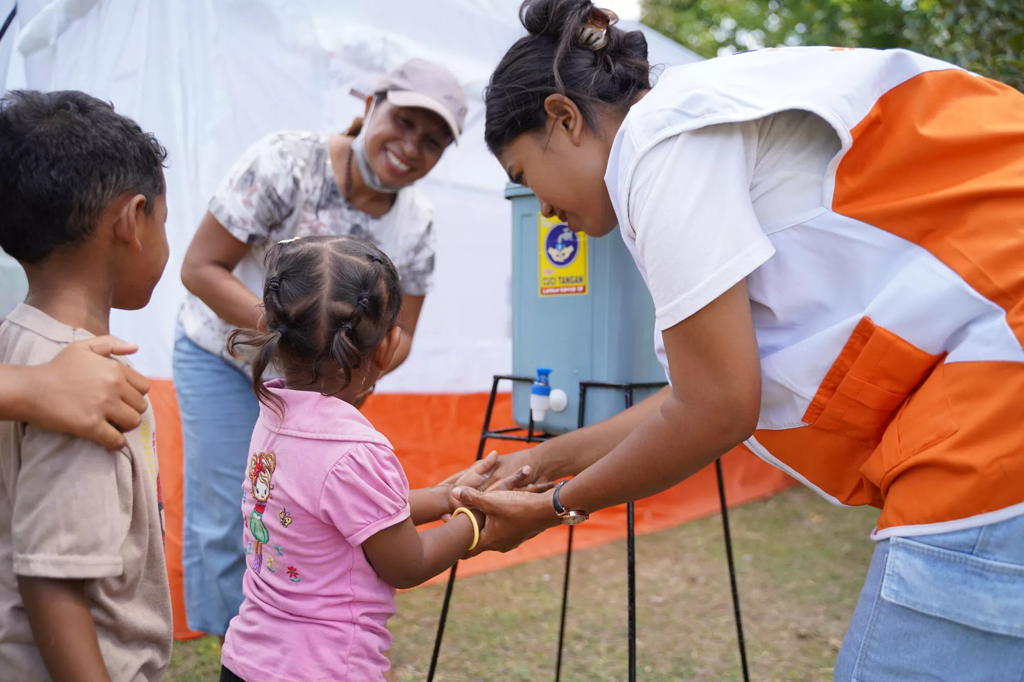 Indonesia Earthquake Response Child washing hands with World Vision Staff