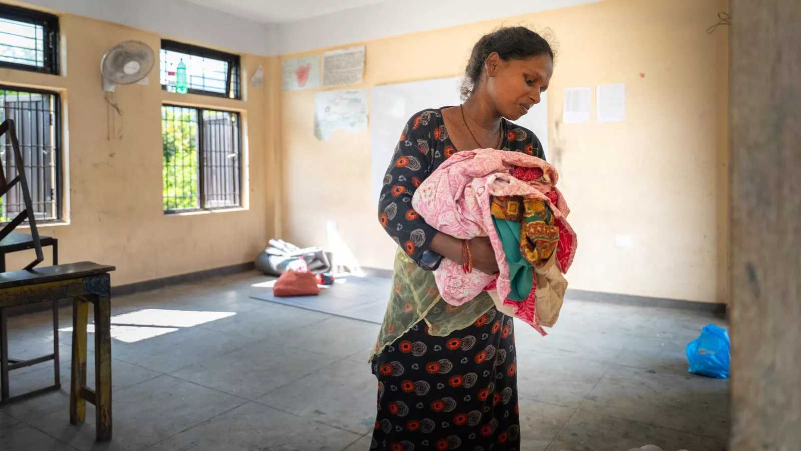 Urmila sorts through her clothes at a temporary evacuation centre in Nuwakot