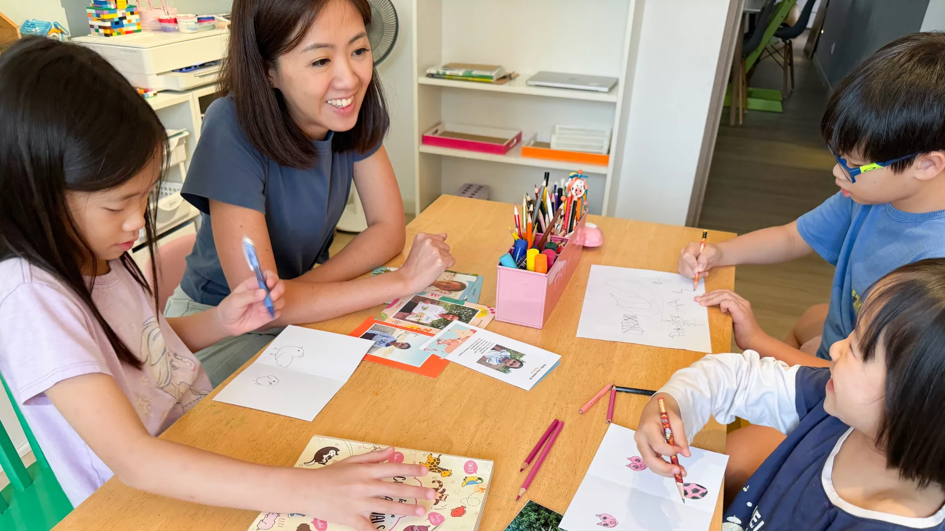 Fynn, World Vision Singapore's Goodwill Ambassador, and her children writing letters to their sponsored children