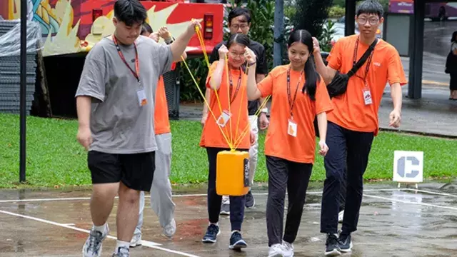 A group of people wearing matching orange shirts participating in an outdoor activity.