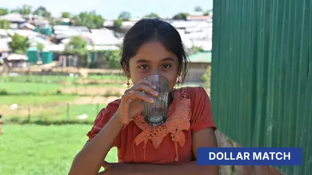 A young girl drinking from a glass in a village.