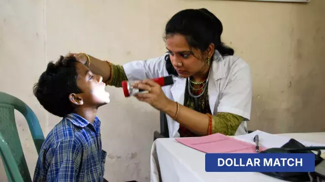 Healthcare worker examining child’s mouth with dollar match label
