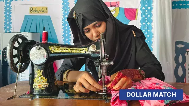 Person sewing floral fabric on vintage machine with dollar match label