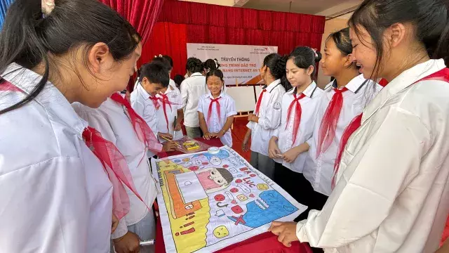 School children looking at educational materials together.